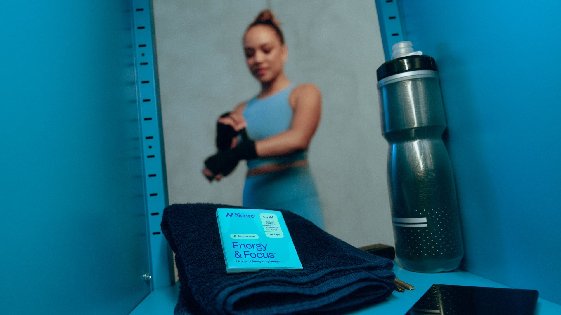 A woman in the gym locker room with a packet of Neuro Energy & Focus gum among her personal items