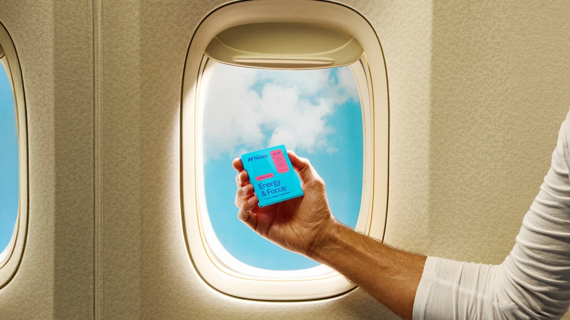 man traveling by plane holds a packet of Neuro Energy & Focus Watermelon gum