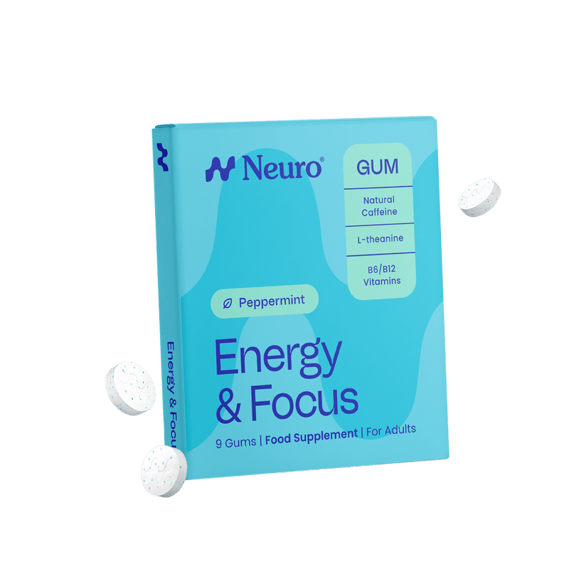 A box of Neuro Energy & Focus GUM food supplement for adults, shown floating on a solid black background with three white gummy tablets floating around it. The box is light blue with dark blue text and accents, and features a 'Peppermint' flavor label.
